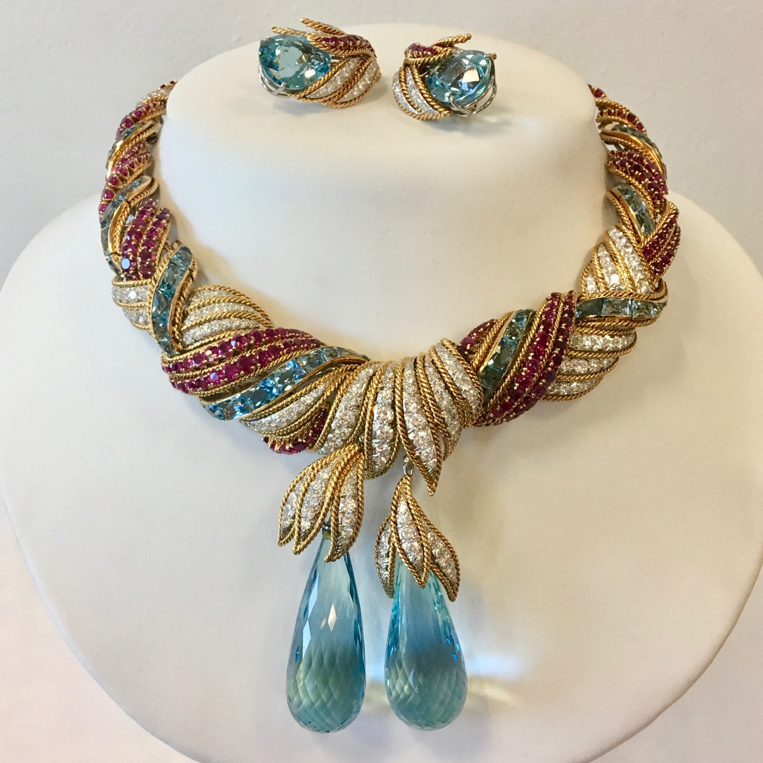 A necklace and earrings set with blue, red and gold stones.