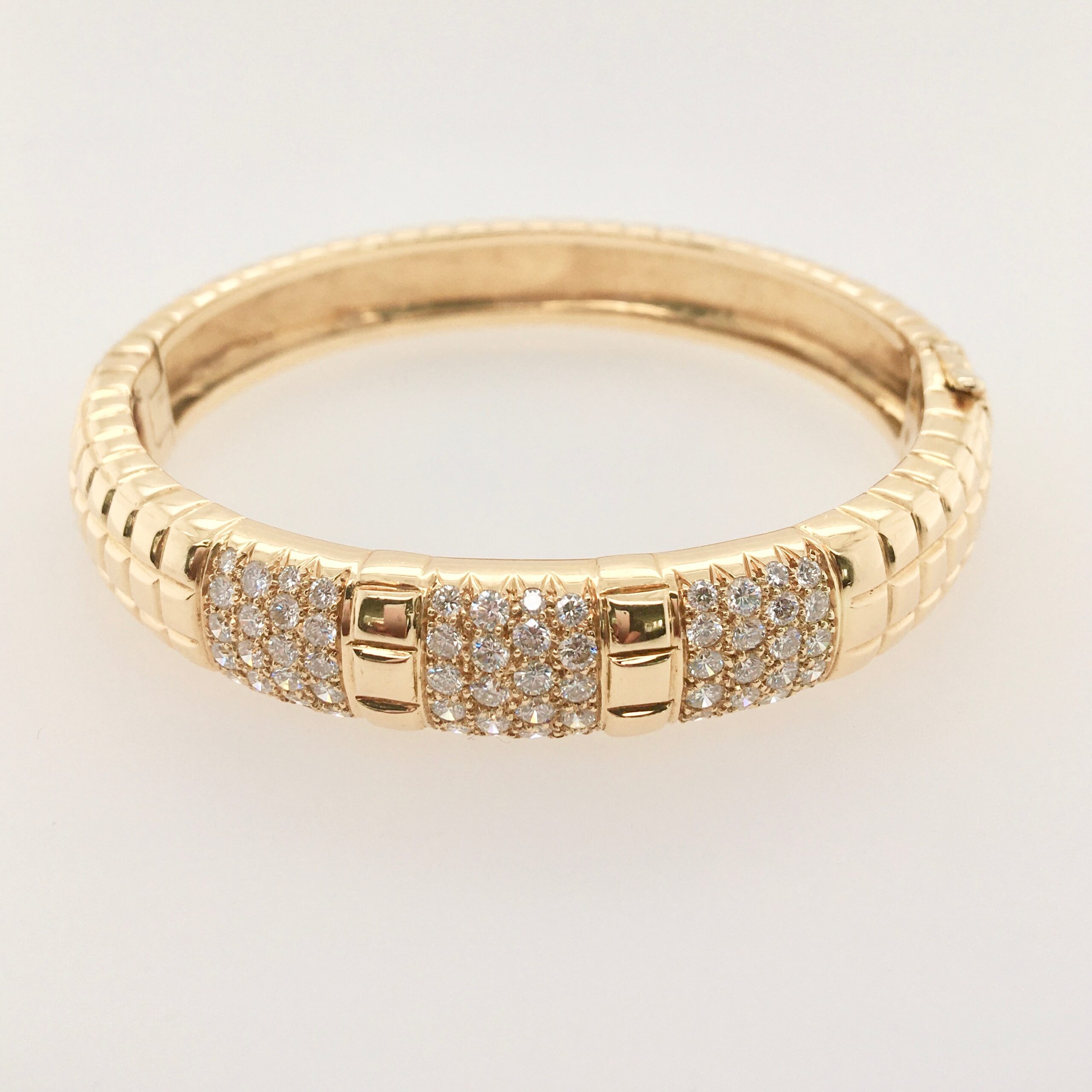 A gold bracelet with some white stones on it