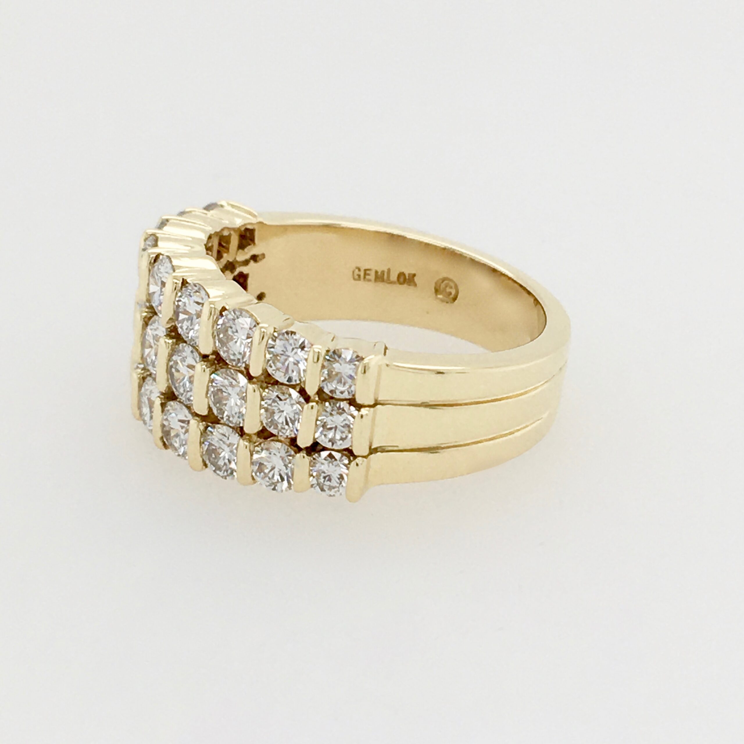 A gold ring with three rows of diamonds on it.