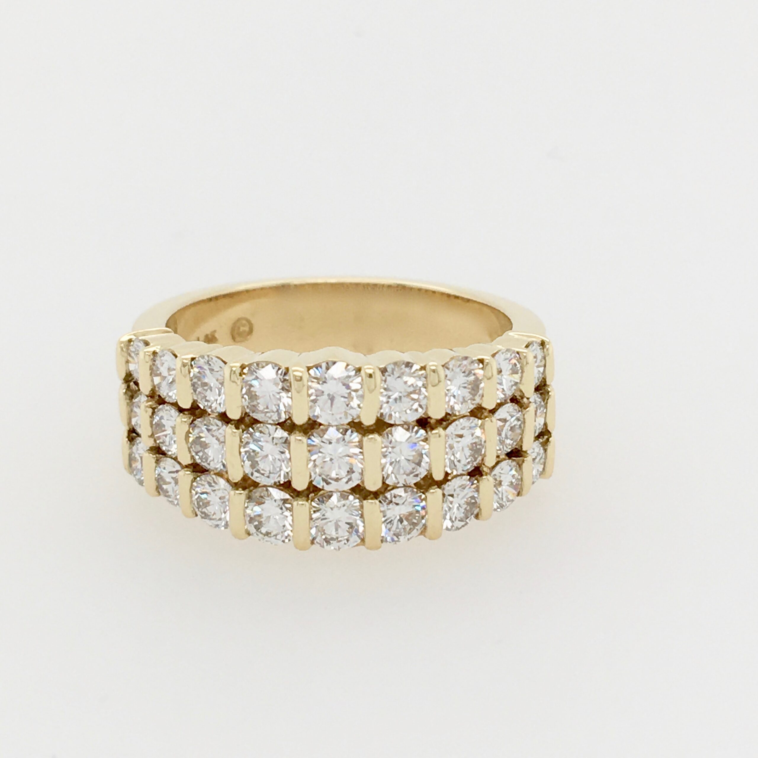 A gold ring with three rows of diamonds on it.