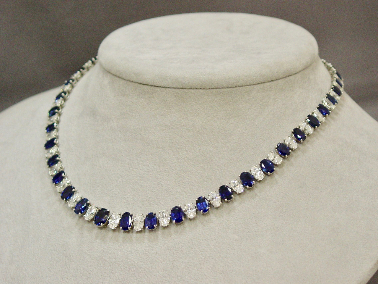 A necklace is shown on display in front of a white background.