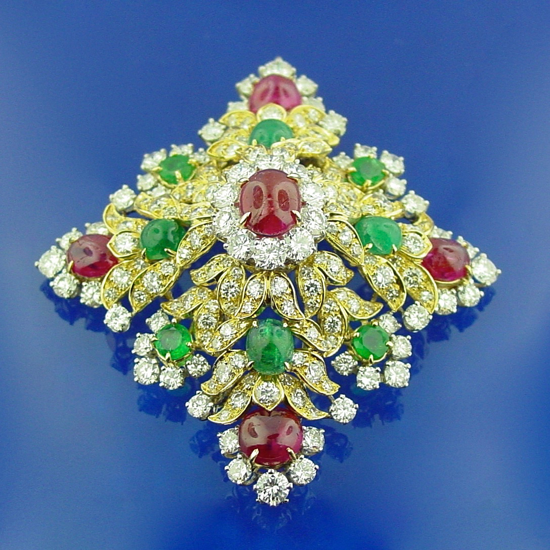A diamond and ruby brooch with green stones.