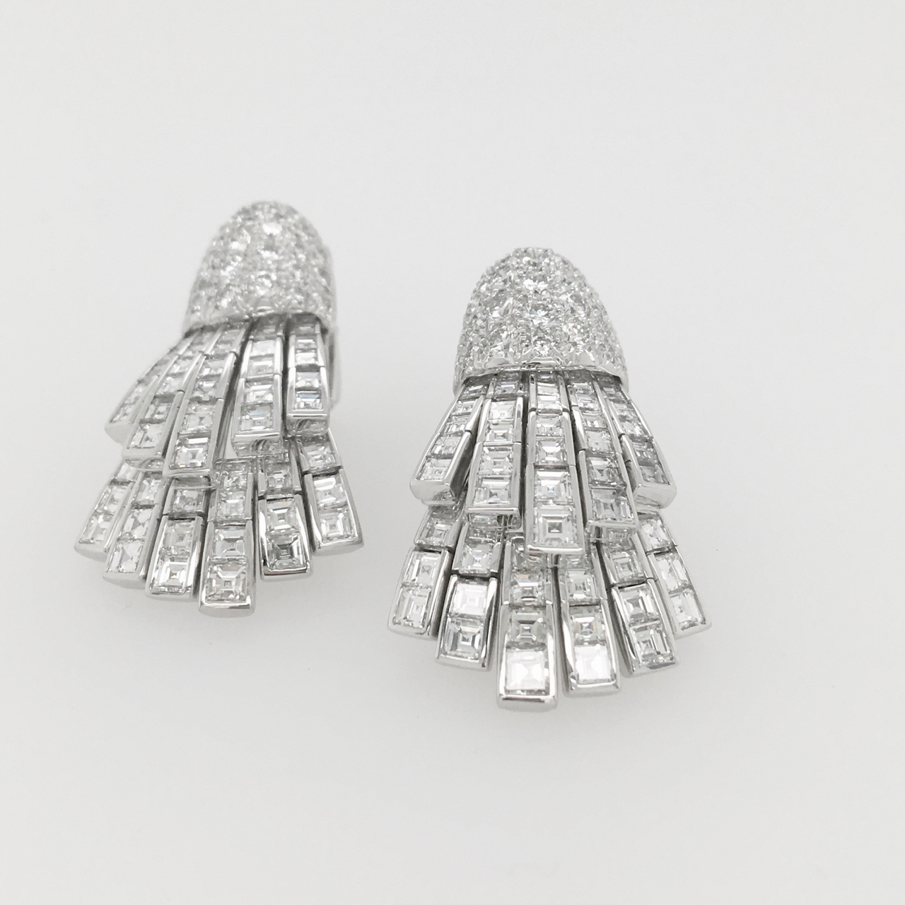 A pair of diamond earrings with two rows of diamonds.