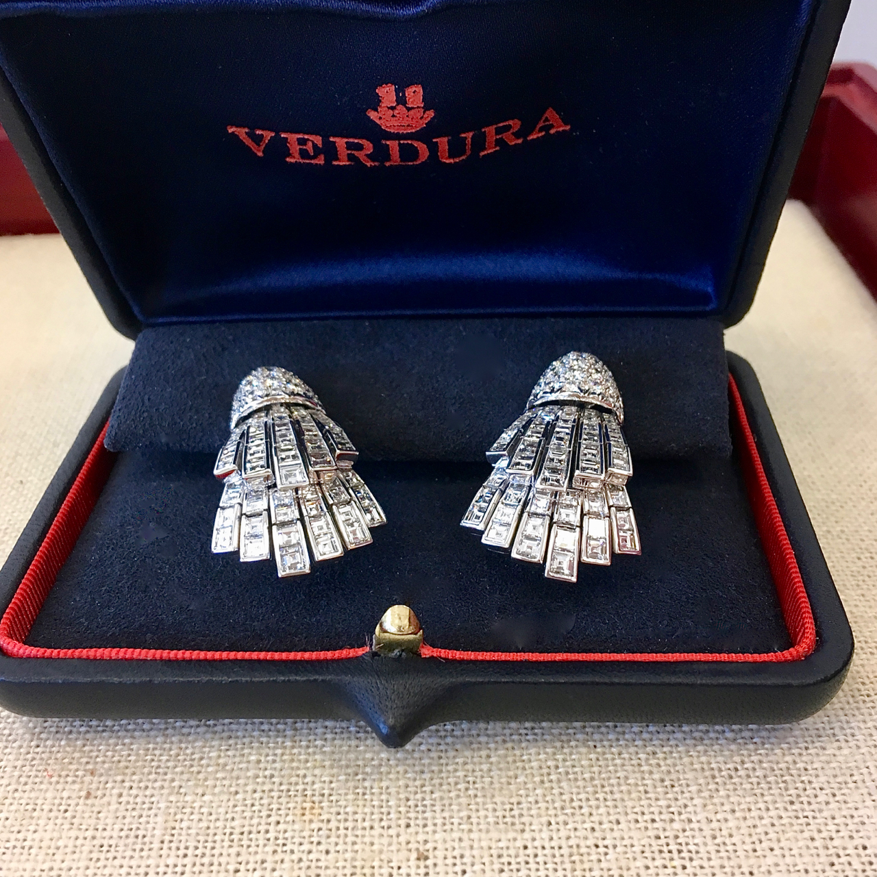 A pair of silver earrings in the shape of a hand.
