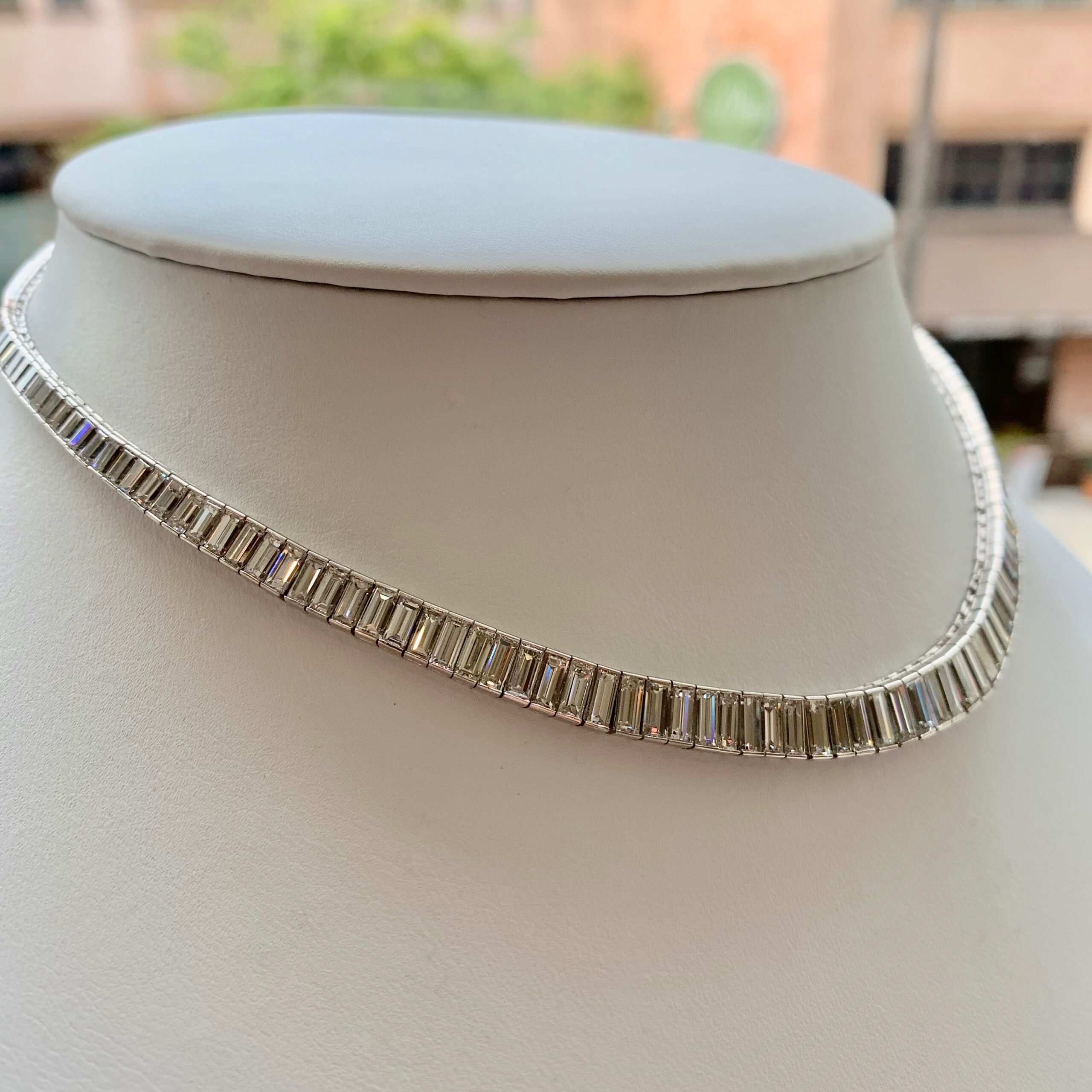 A necklace is shown on the neck of a woman.