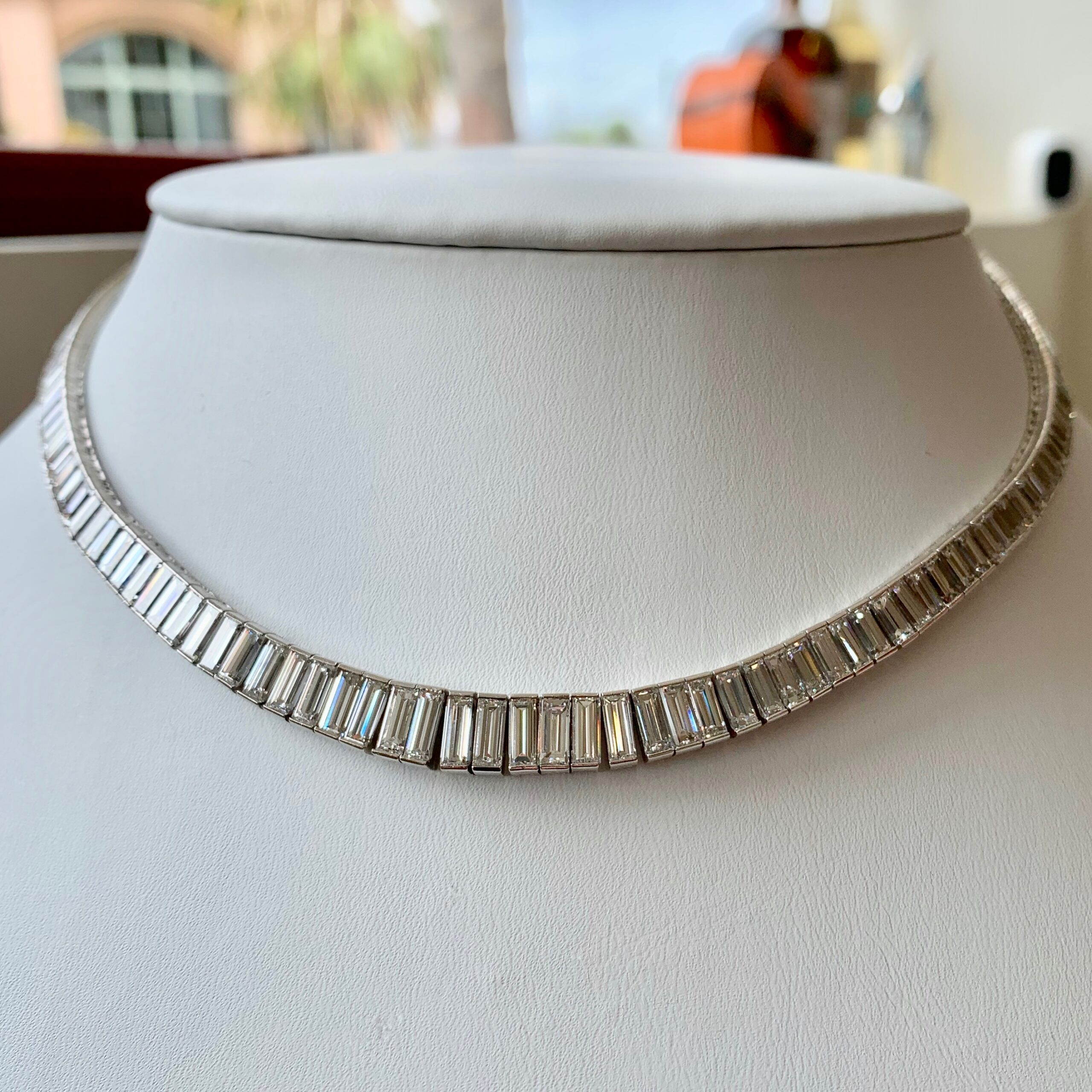 A necklace is shown on top of a white bust.