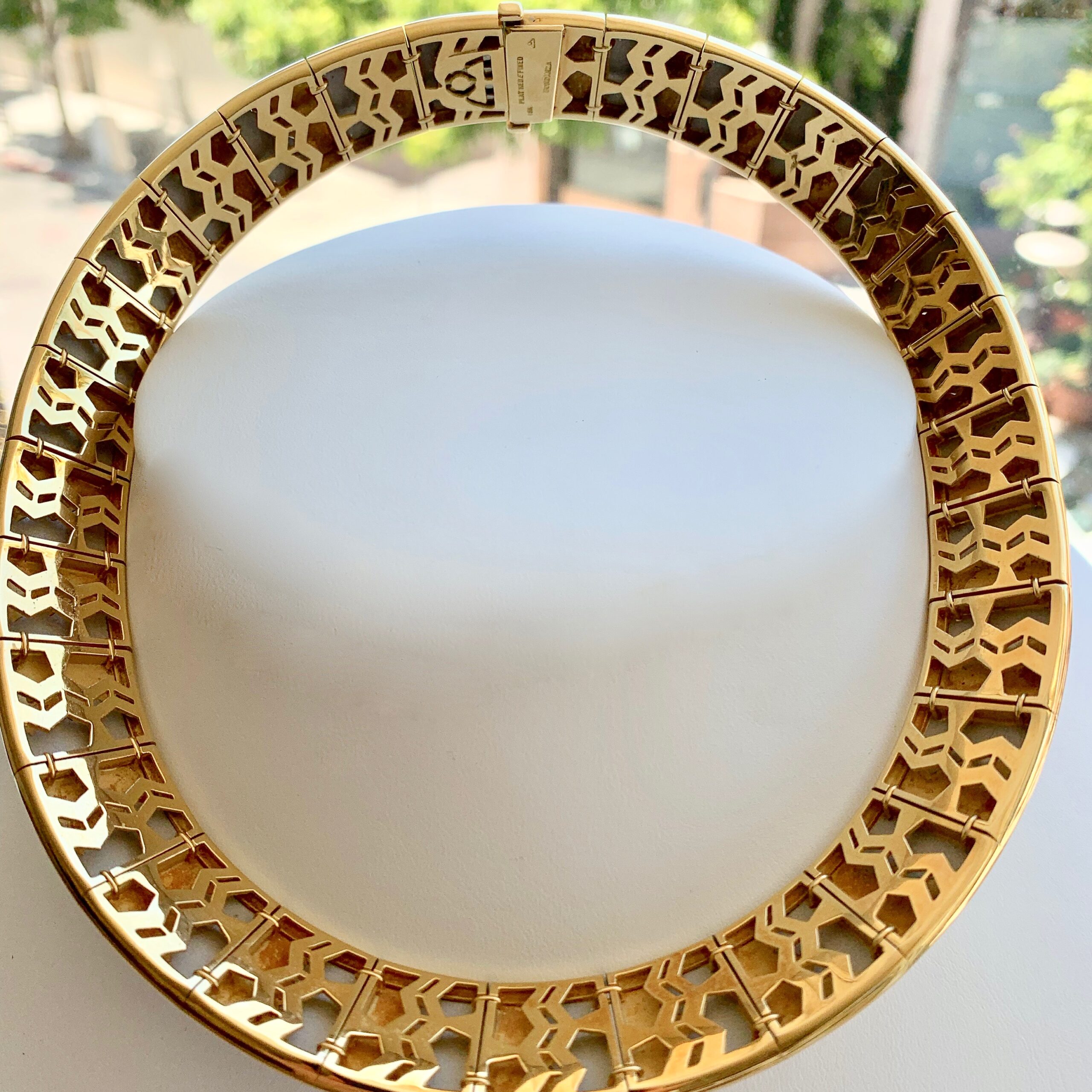 A gold colored metal chain with a white background