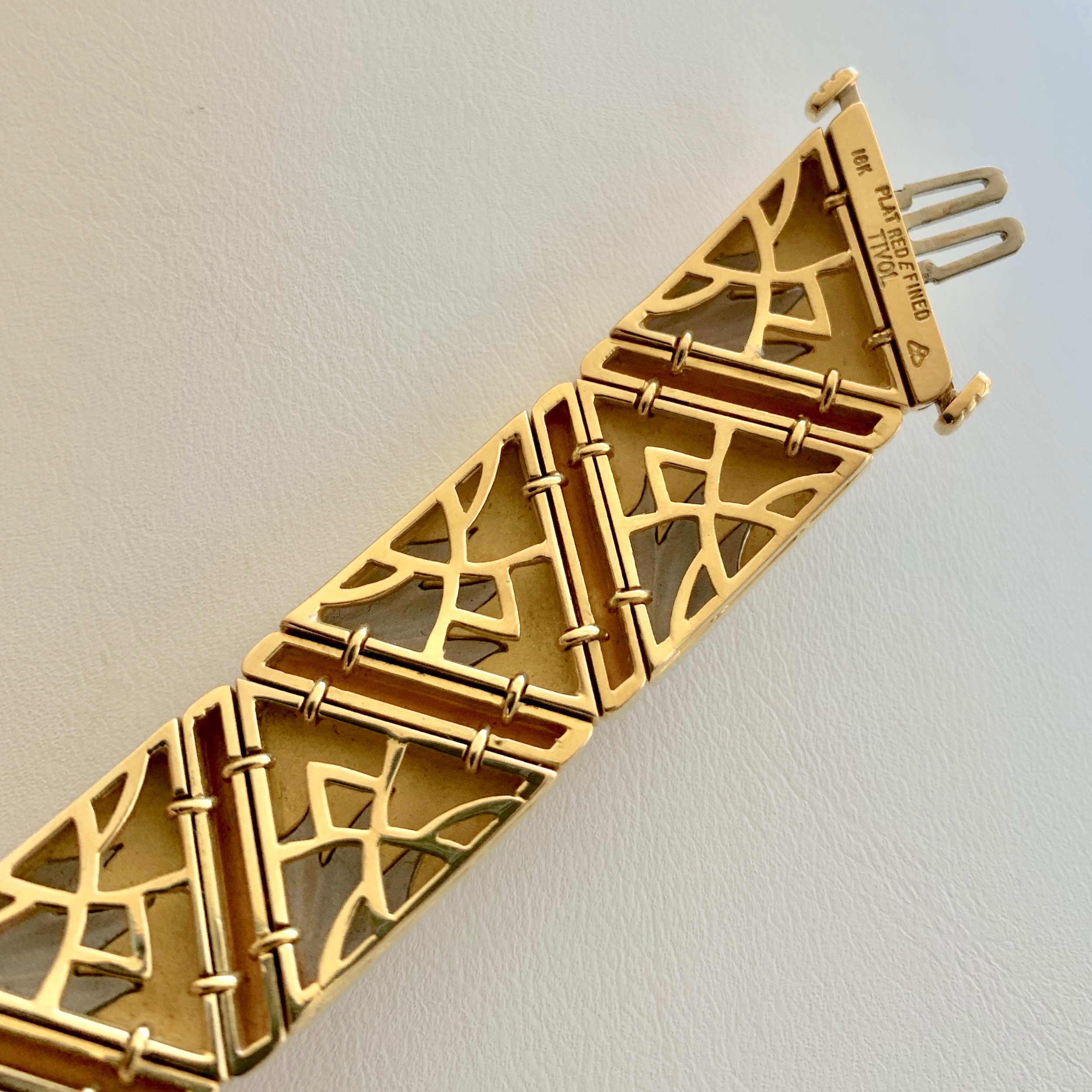 A gold bracelet with a design on it.