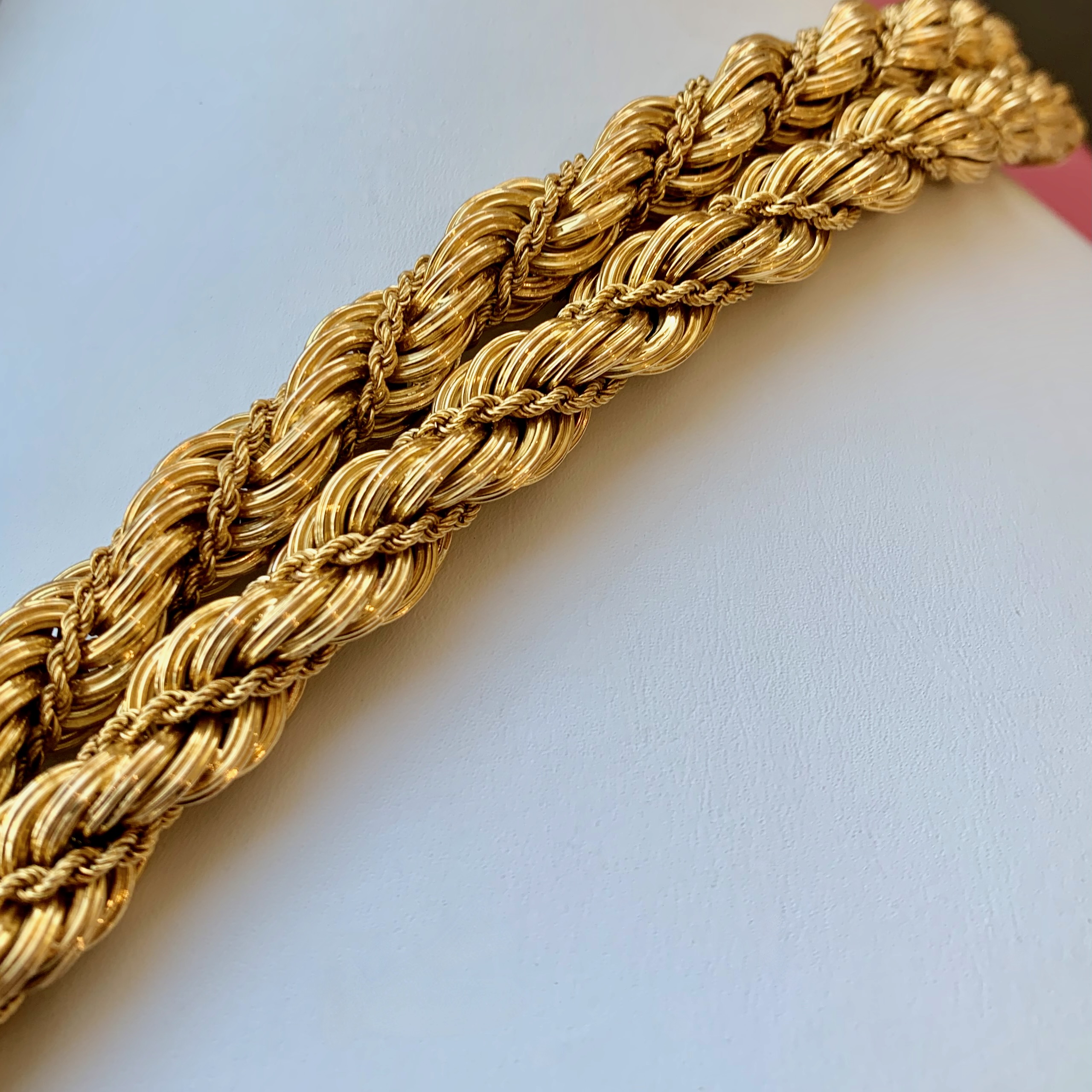 A close up of the gold chain on someones wrist