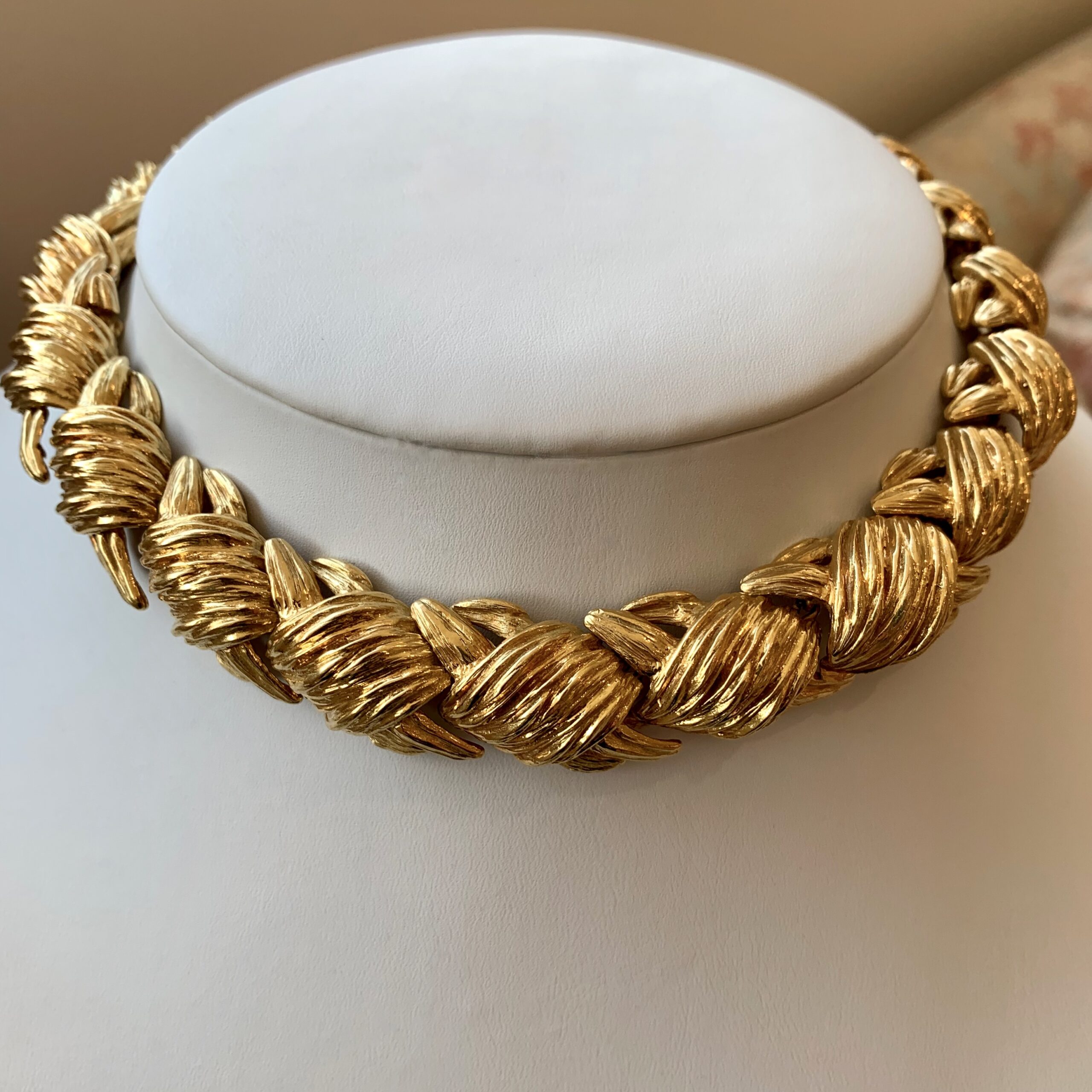 A gold necklace sitting on top of a white counter.