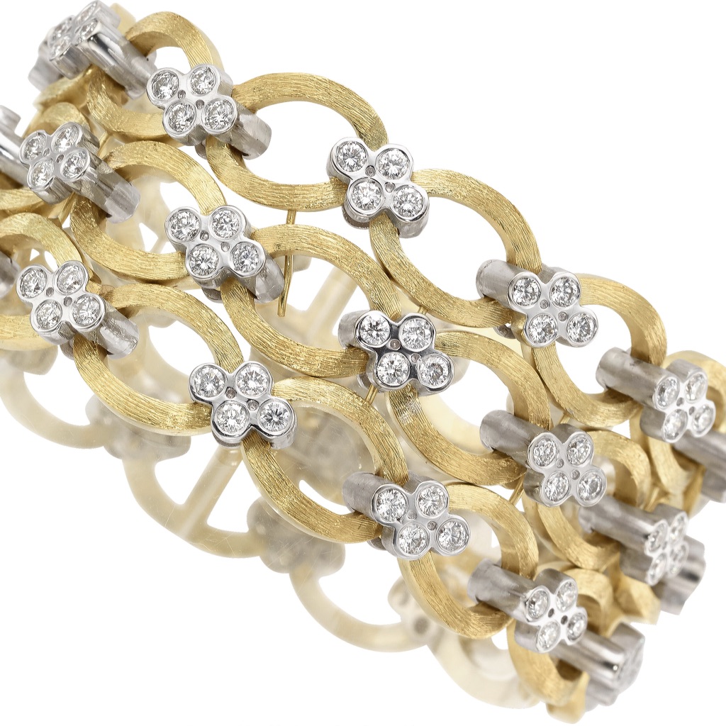 A gold and diamond bracelet with four rows of flowers.
