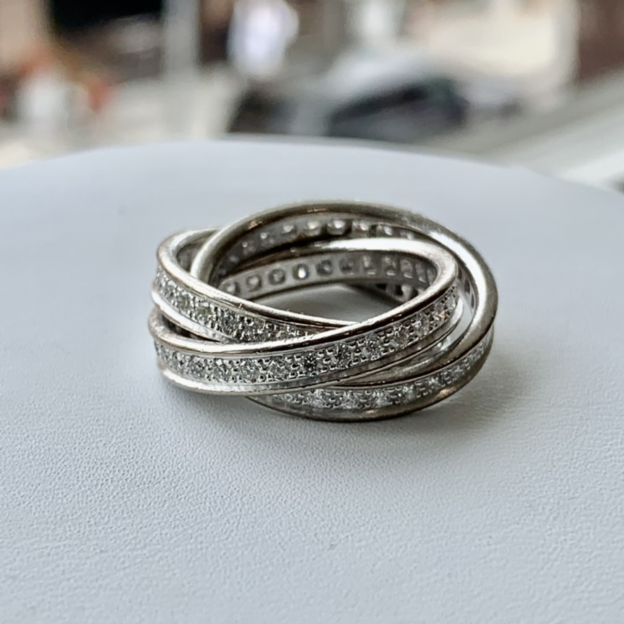 A white ring with three bands of diamonds on top