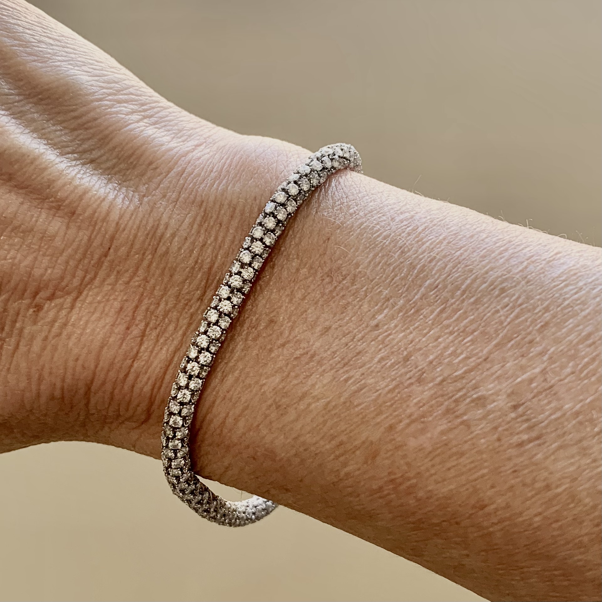 A person wearing a bracelet with diamonds on it