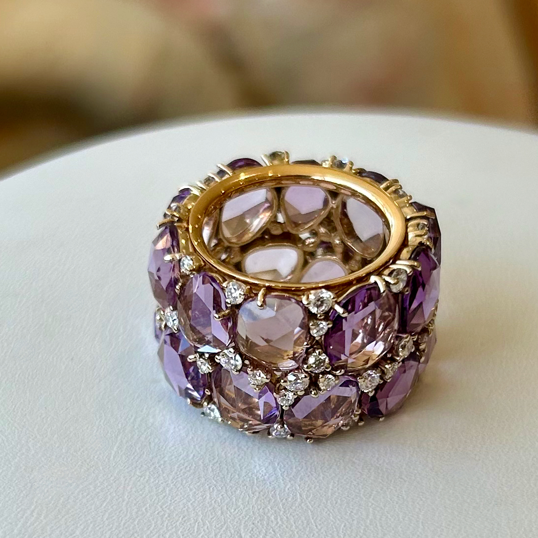 A purple and gold ring sitting on top of a table.