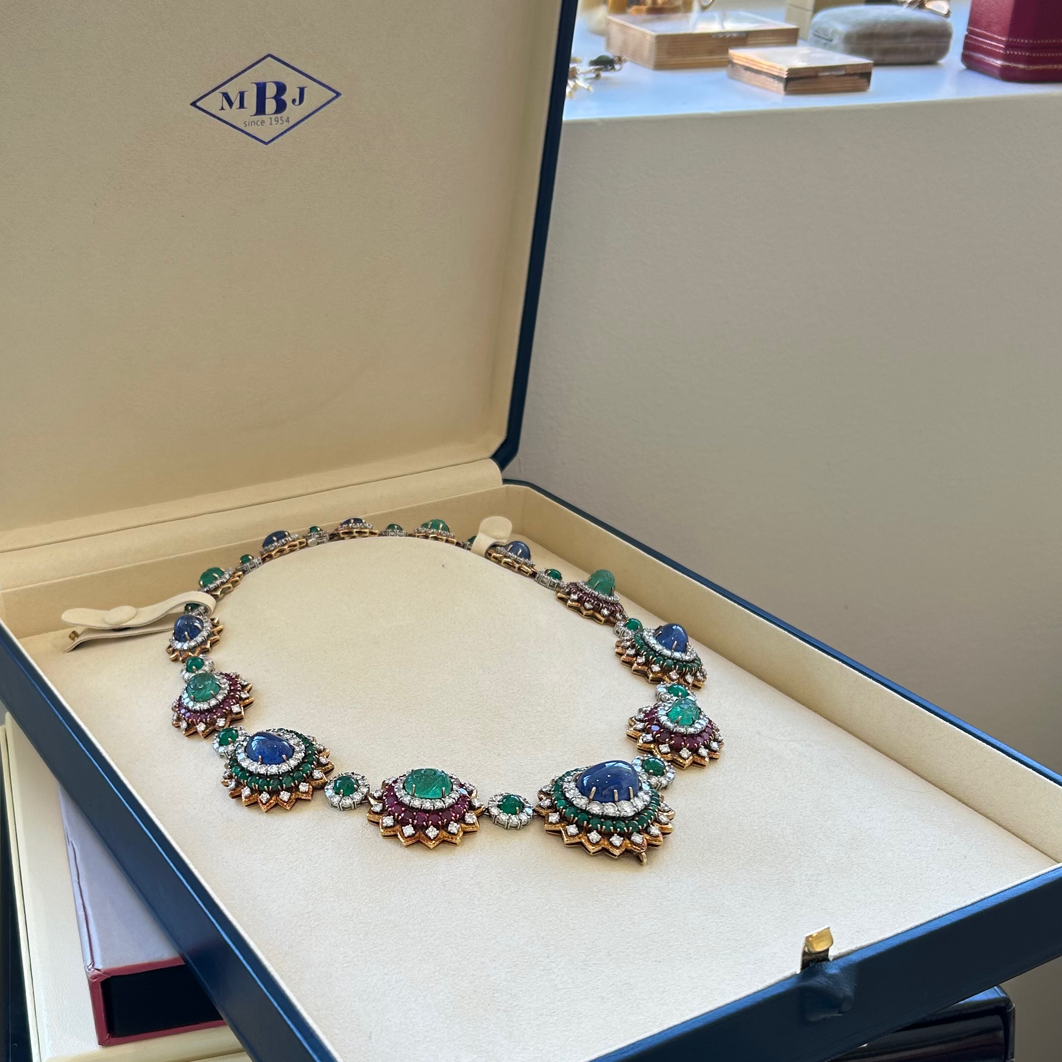 A necklace in a box with some jewels on it